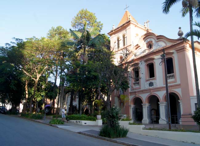 Imagem da fachada da igreja da PUC São Paulo com árvores ao lado esquerdo da imagem