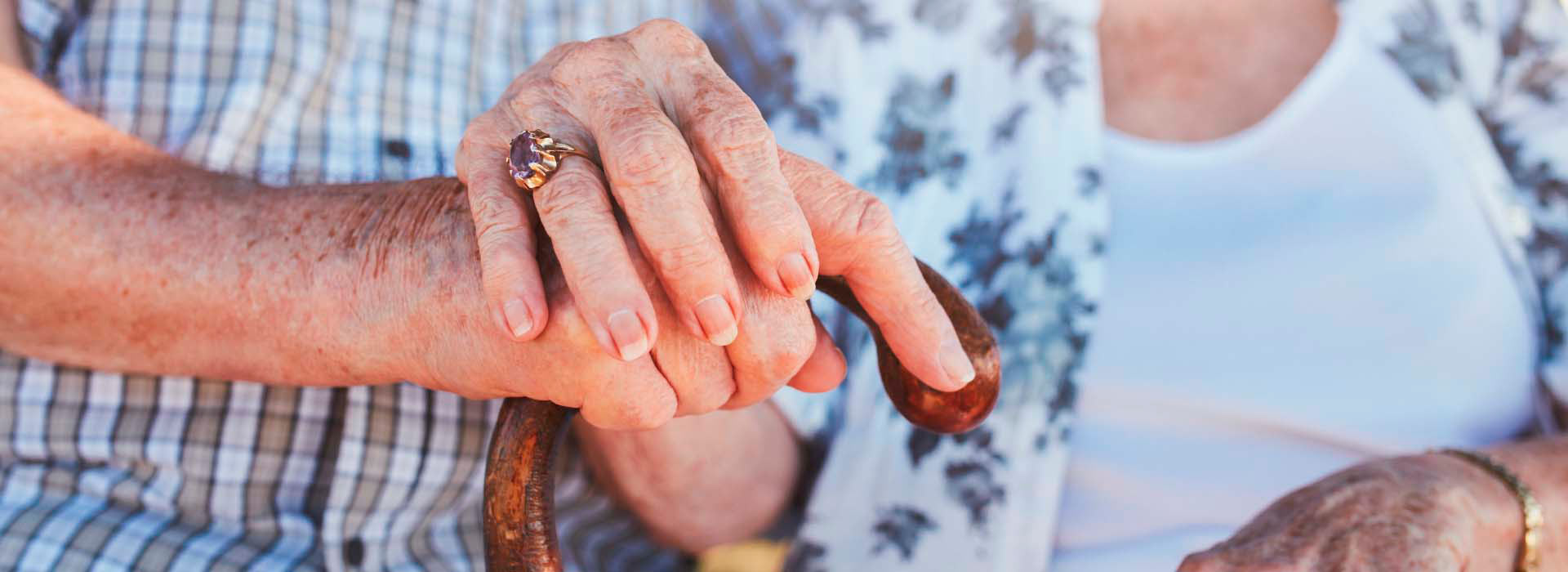 Imagem de duas pessoas idosas de mãos dadas